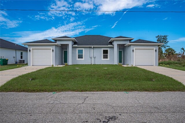 view of front facade featuring a front yard, a garage, and cooling unit