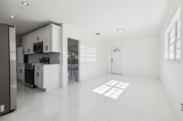 kitchen with white cabinetry, light tile patterned floors, and stainless steel appliances