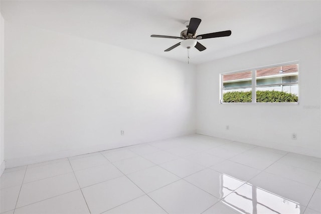 tiled spare room with ceiling fan