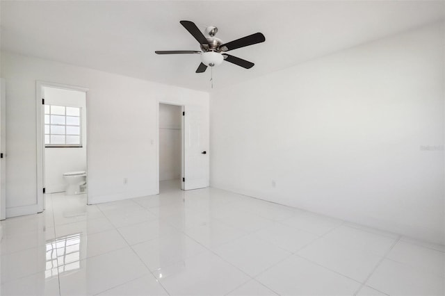 tiled spare room featuring ceiling fan