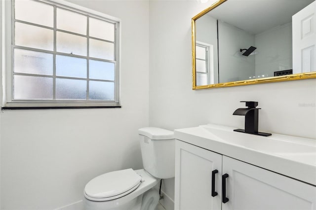 bathroom featuring a shower, vanity, and toilet