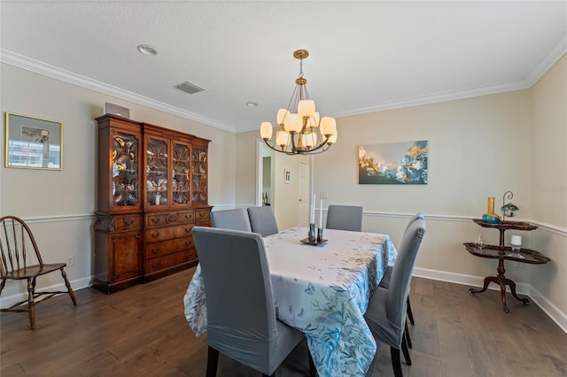 dining room with a notable chandelier, dark hardwood / wood-style flooring, ornamental molding, and a textured ceiling