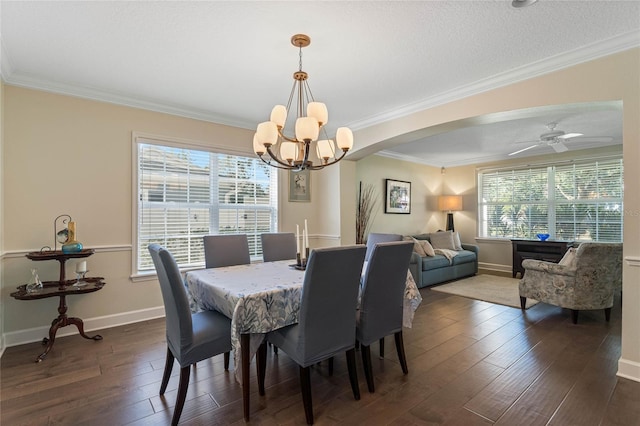 dining room with dark hardwood / wood-style floors, crown molding, and ceiling fan with notable chandelier