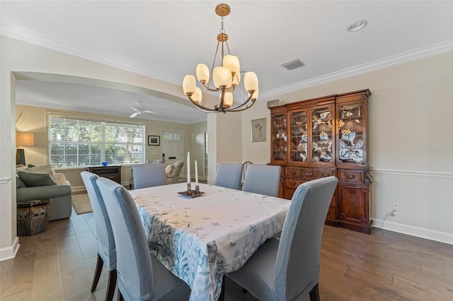 dining room featuring hardwood / wood-style floors, ceiling fan with notable chandelier, and ornamental molding