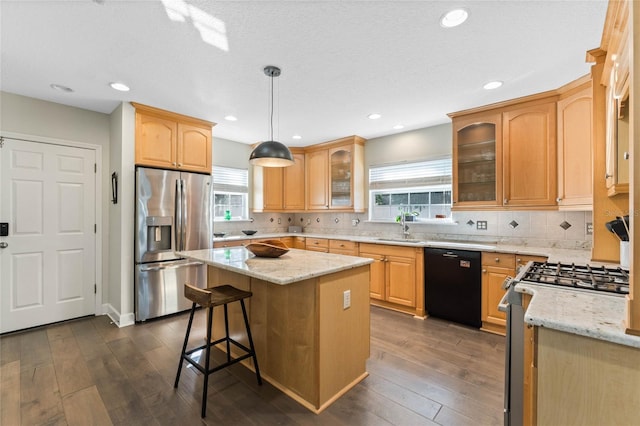 kitchen with dark wood-type flooring, a center island, pendant lighting, and appliances with stainless steel finishes