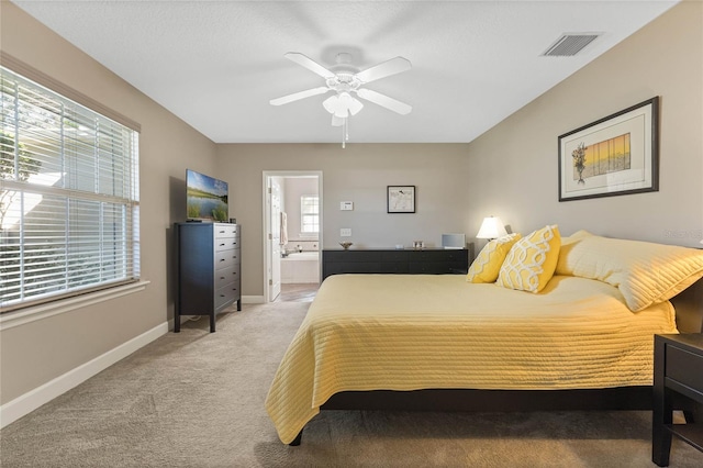 carpeted bedroom with ceiling fan and ensuite bath