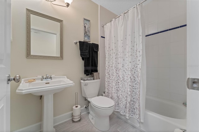 full bathroom featuring sink, toilet, and shower / tub combo with curtain