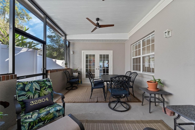 sunroom / solarium featuring ceiling fan, french doors, and a healthy amount of sunlight