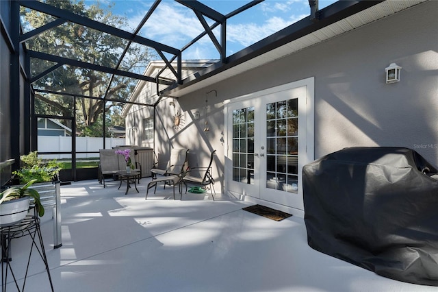 view of patio with glass enclosure, grilling area, and french doors