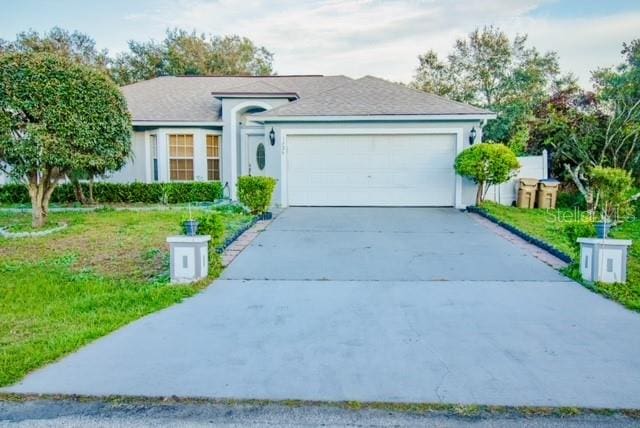 ranch-style home featuring a front lawn and a garage