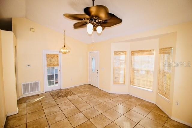 tiled spare room featuring ceiling fan, a healthy amount of sunlight, and vaulted ceiling