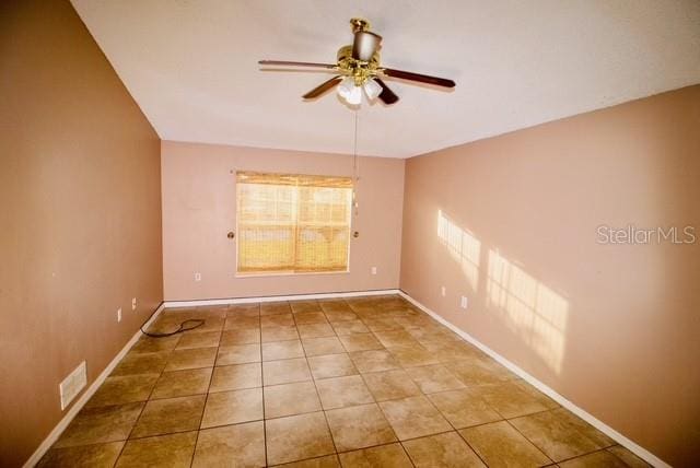 tiled empty room with ceiling fan