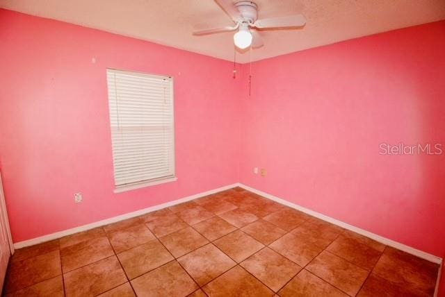 spare room featuring tile patterned floors and ceiling fan