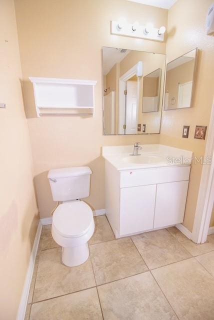 bathroom with tile patterned floors, vanity, and toilet