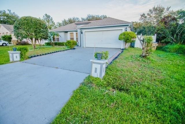 ranch-style house featuring a front yard and a garage