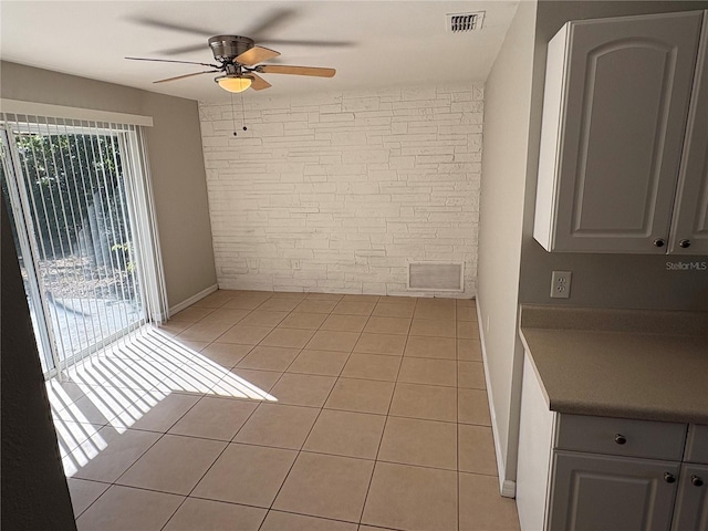 empty room with ceiling fan and light tile patterned flooring