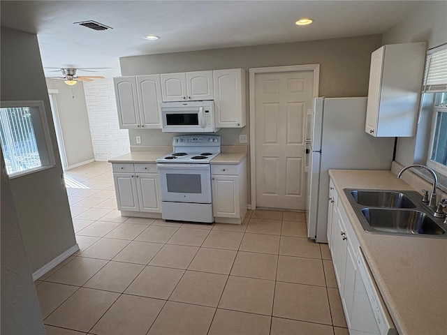 kitchen with white cabinetry, sink, white appliances, and light tile patterned floors