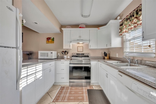 kitchen with white cabinetry, sink, light tile patterned floors, and white appliances