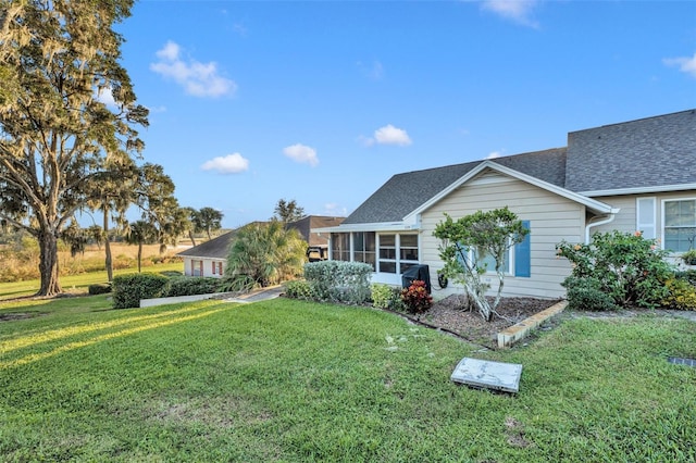 view of front of home with a front lawn and a sunroom