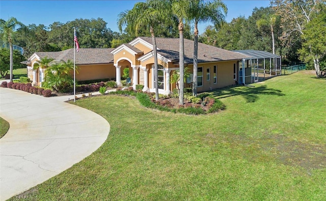 view of front of house featuring glass enclosure and a front lawn