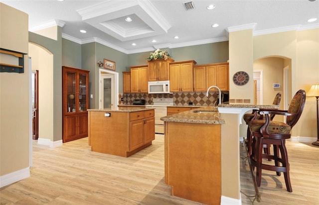 kitchen featuring kitchen peninsula, white appliances, light hardwood / wood-style flooring, and sink