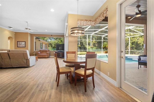 dining room featuring hardwood / wood-style floors, ceiling fan, ornamental molding, and a wealth of natural light