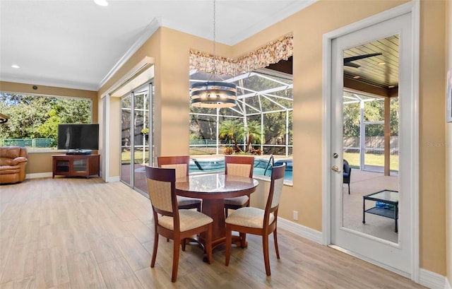 dining area with hardwood / wood-style flooring, ornamental molding, and an inviting chandelier