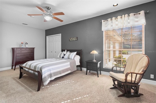 carpeted bedroom featuring ceiling fan and a closet