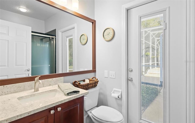 bathroom with vanity, toilet, and an enclosed shower