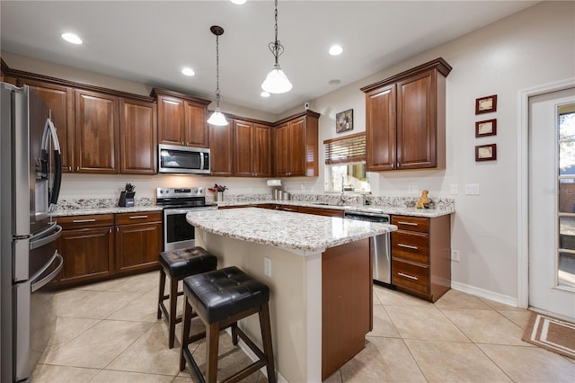 kitchen featuring a healthy amount of sunlight, hanging light fixtures, a kitchen island, and stainless steel appliances