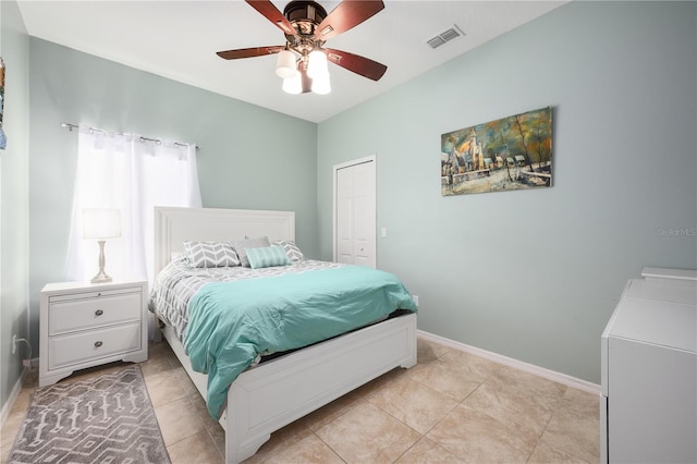 tiled bedroom featuring ceiling fan and a closet