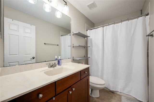 bathroom with toilet, vanity, and tile patterned floors