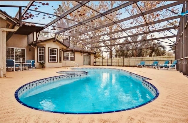 view of swimming pool featuring a lanai, a patio, and an in ground hot tub