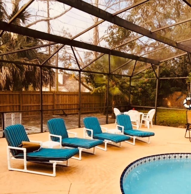 view of pool with a patio area and glass enclosure