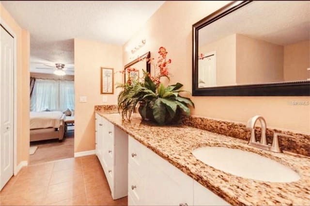 bathroom with tile patterned flooring, vanity, a textured ceiling, and ceiling fan