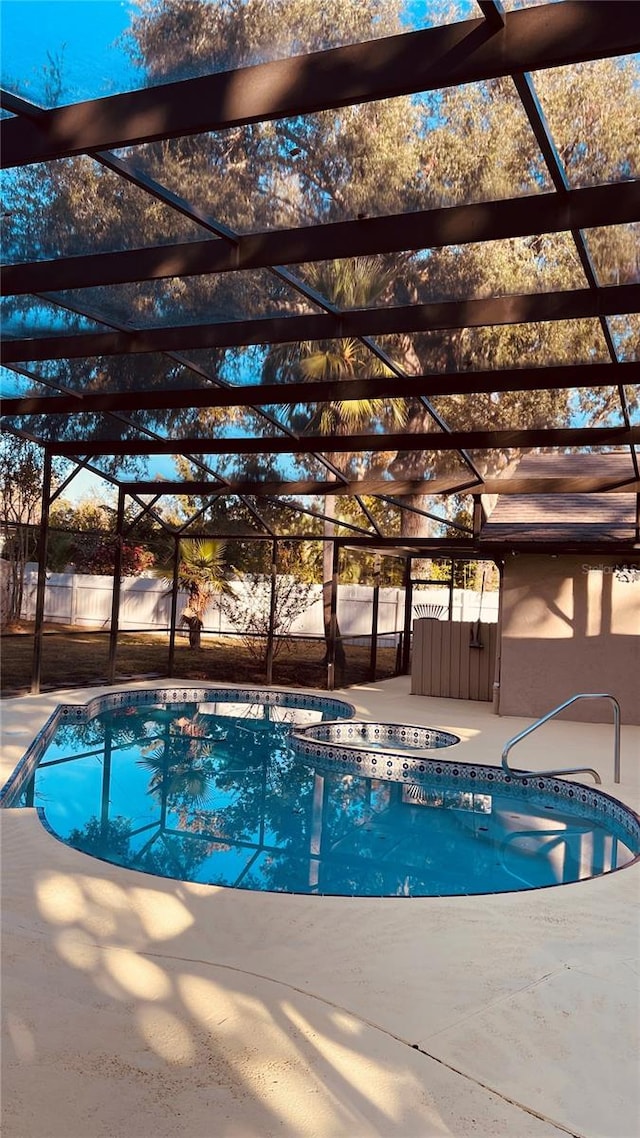 view of pool with an in ground hot tub, a lanai, and a patio area