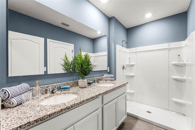 bathroom featuring a shower, tile patterned flooring, and vanity