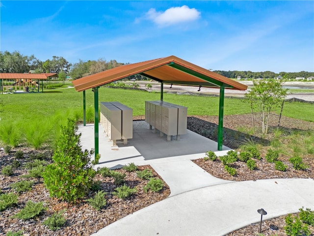 view of community featuring a lawn and a mail area