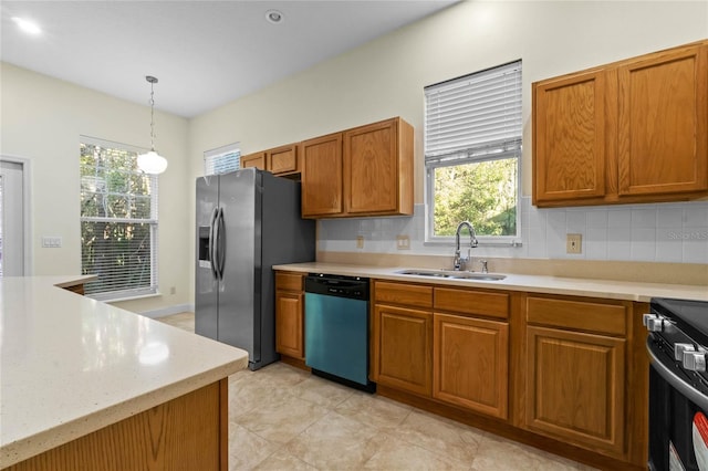 kitchen featuring tasteful backsplash, sink, hanging light fixtures, and appliances with stainless steel finishes