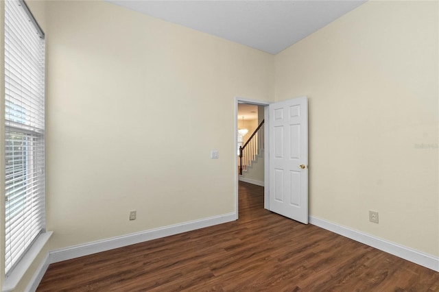 unfurnished room featuring dark wood-type flooring