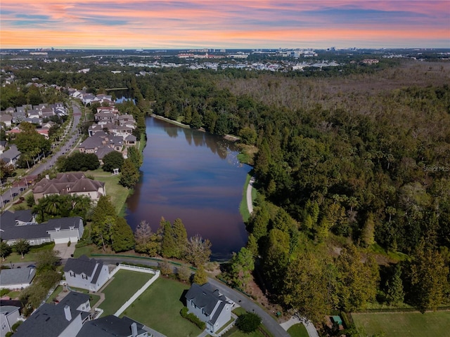 aerial view at dusk featuring a water view