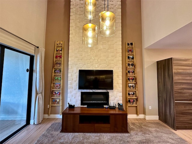 unfurnished living room with hardwood / wood-style floors and a towering ceiling