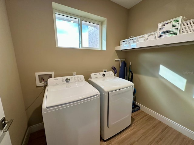 laundry room with light wood-type flooring and washing machine and dryer