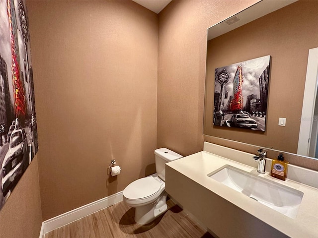 bathroom featuring hardwood / wood-style floors, vanity, and toilet