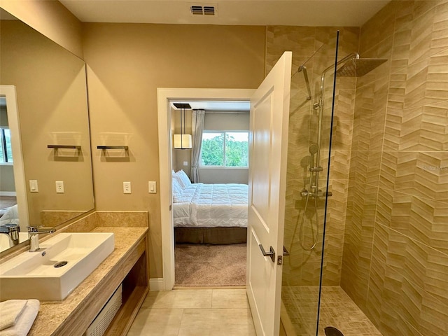 bathroom featuring tile patterned floors, vanity, and a tile shower