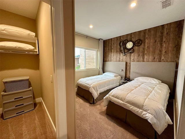 carpeted bedroom featuring wooden walls