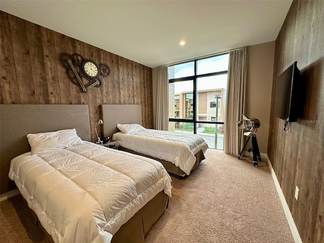 bedroom featuring wood walls, light colored carpet, and access to outside