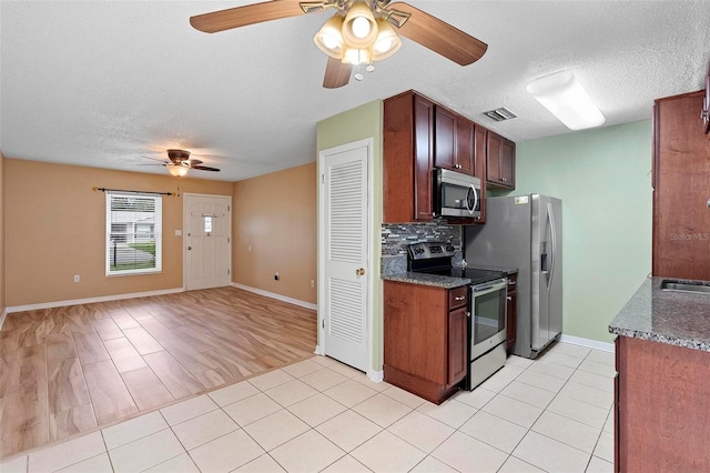 kitchen with decorative backsplash, a textured ceiling, stainless steel appliances, and light hardwood / wood-style flooring