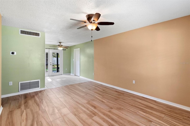 spare room featuring a textured ceiling, light hardwood / wood-style floors, and ceiling fan