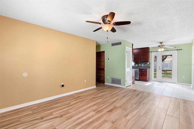 unfurnished living room featuring light wood-type flooring, a textured ceiling, and ceiling fan